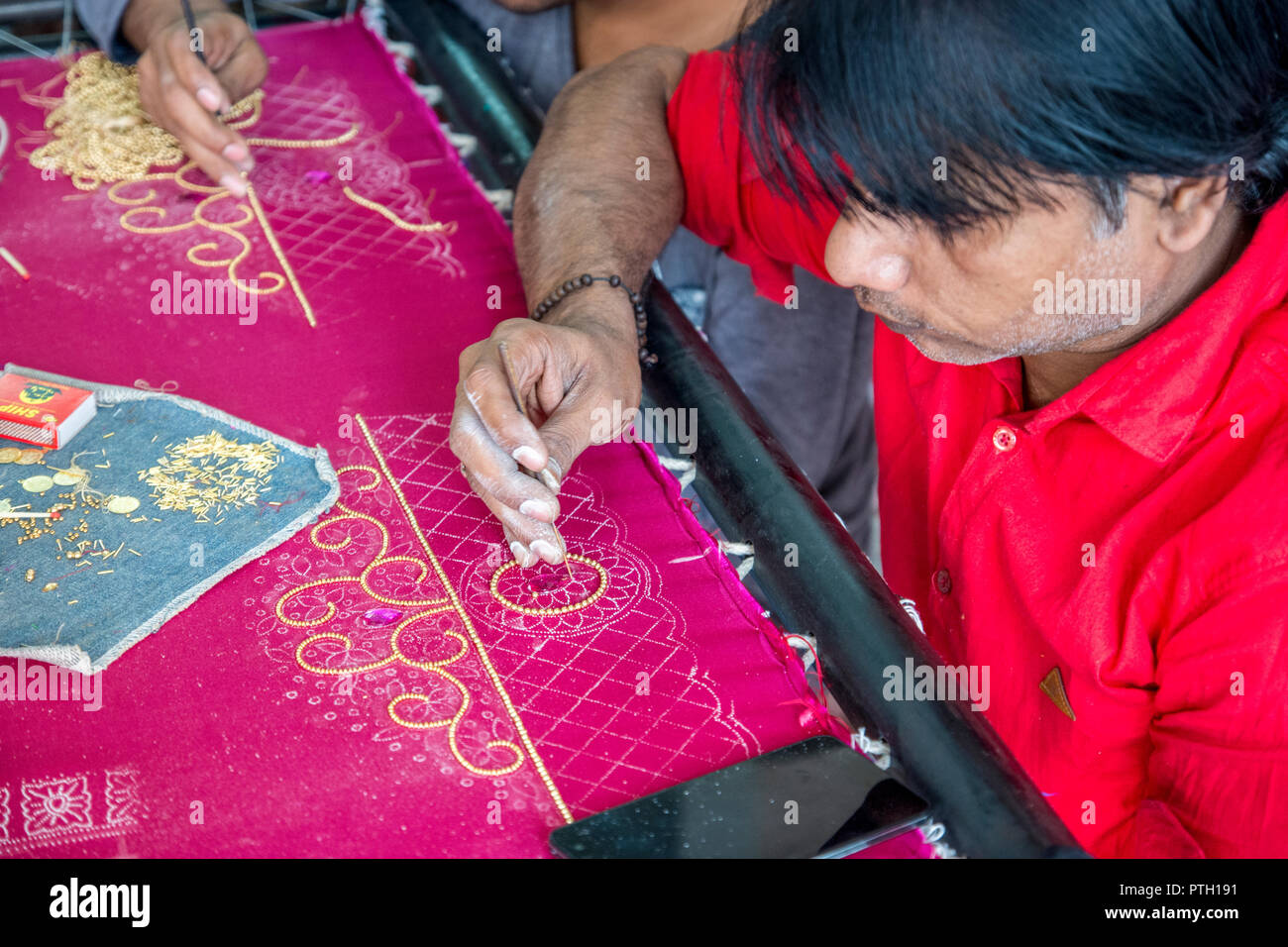 Craftsmen performing embroidery work on a Saree. Photographed in Ahmedabad, Gujarat, India Stock Photo