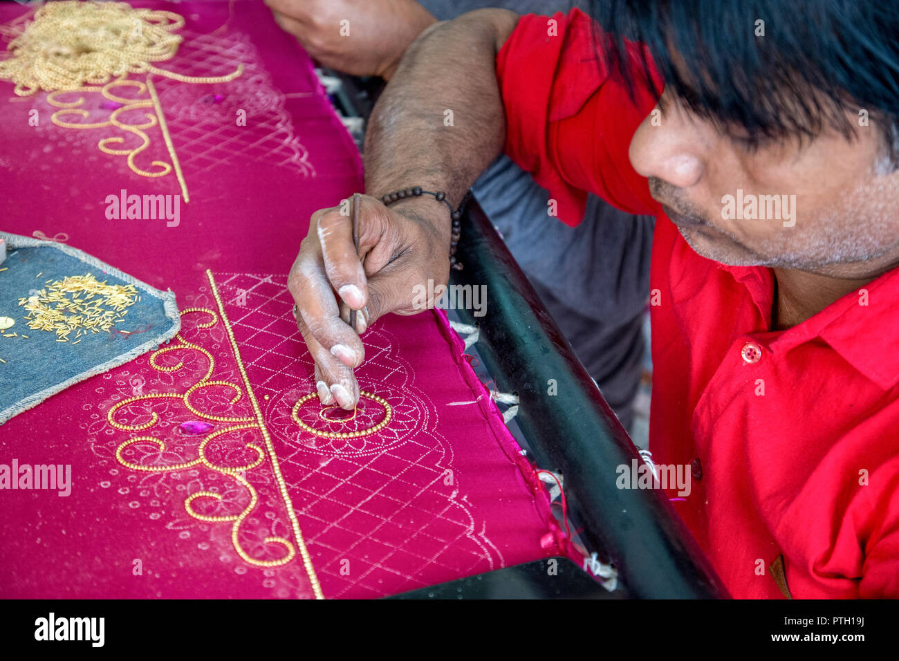 Craftsmen performing embroidery work on a Saree. Photographed in Ahmedabad, Gujarat, India Stock Photo