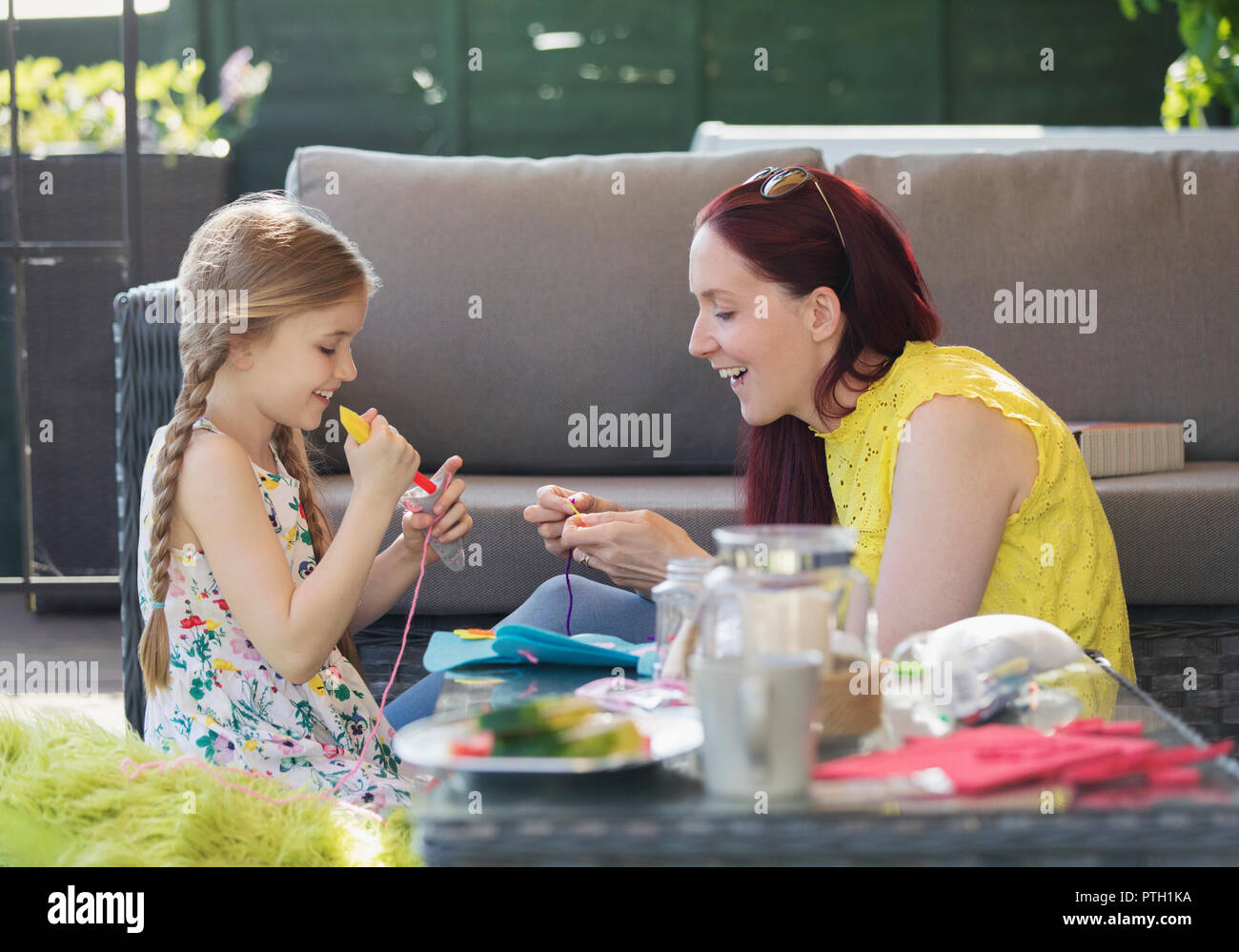 Mother and daughter doing craft project on patio Stock Photo