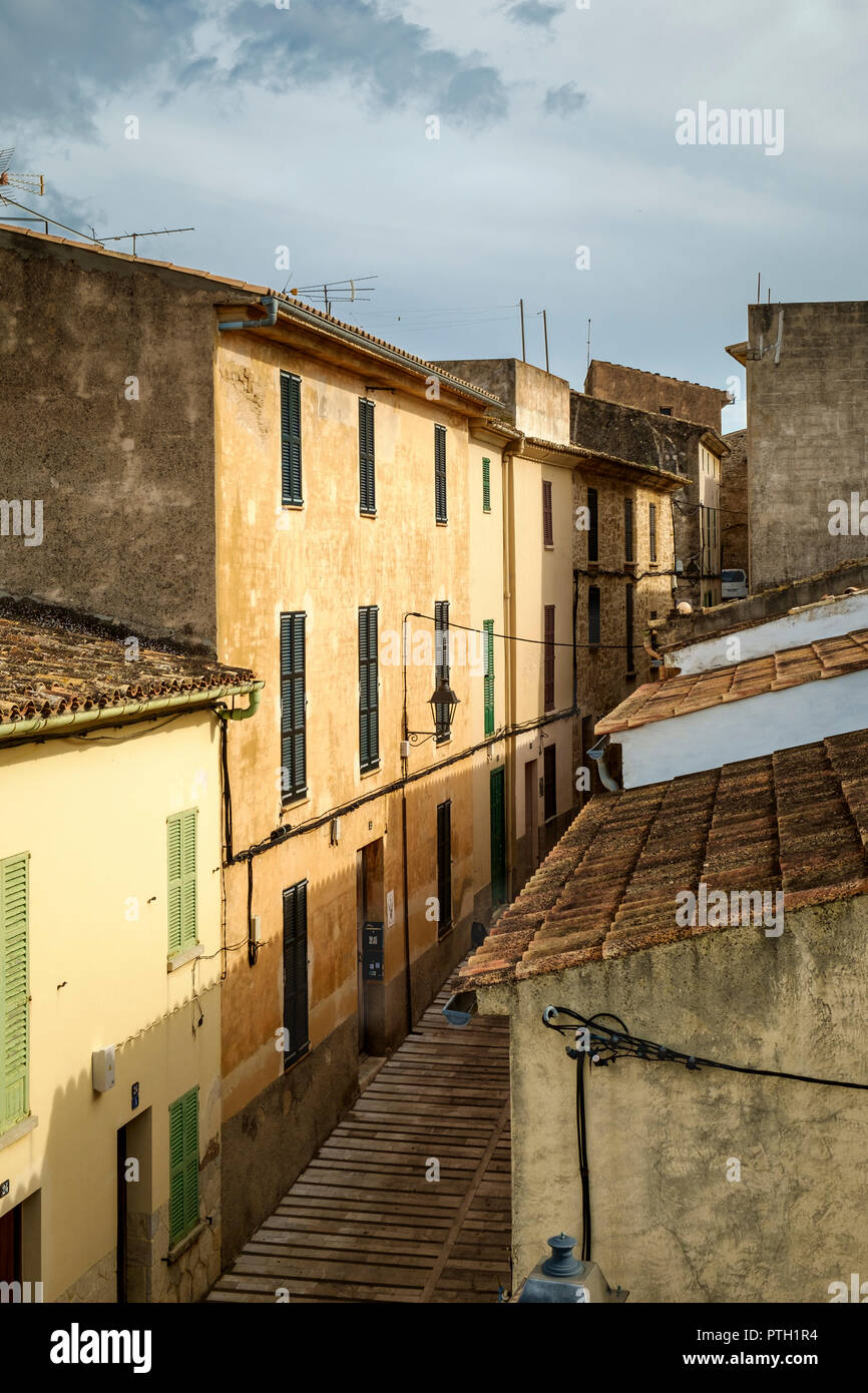 Typical buildings with traditional green shutters, terracotta roof tiles and ochre coloured stucco facade, the old town of Alcudia, Mallorca, Spain Stock Photo