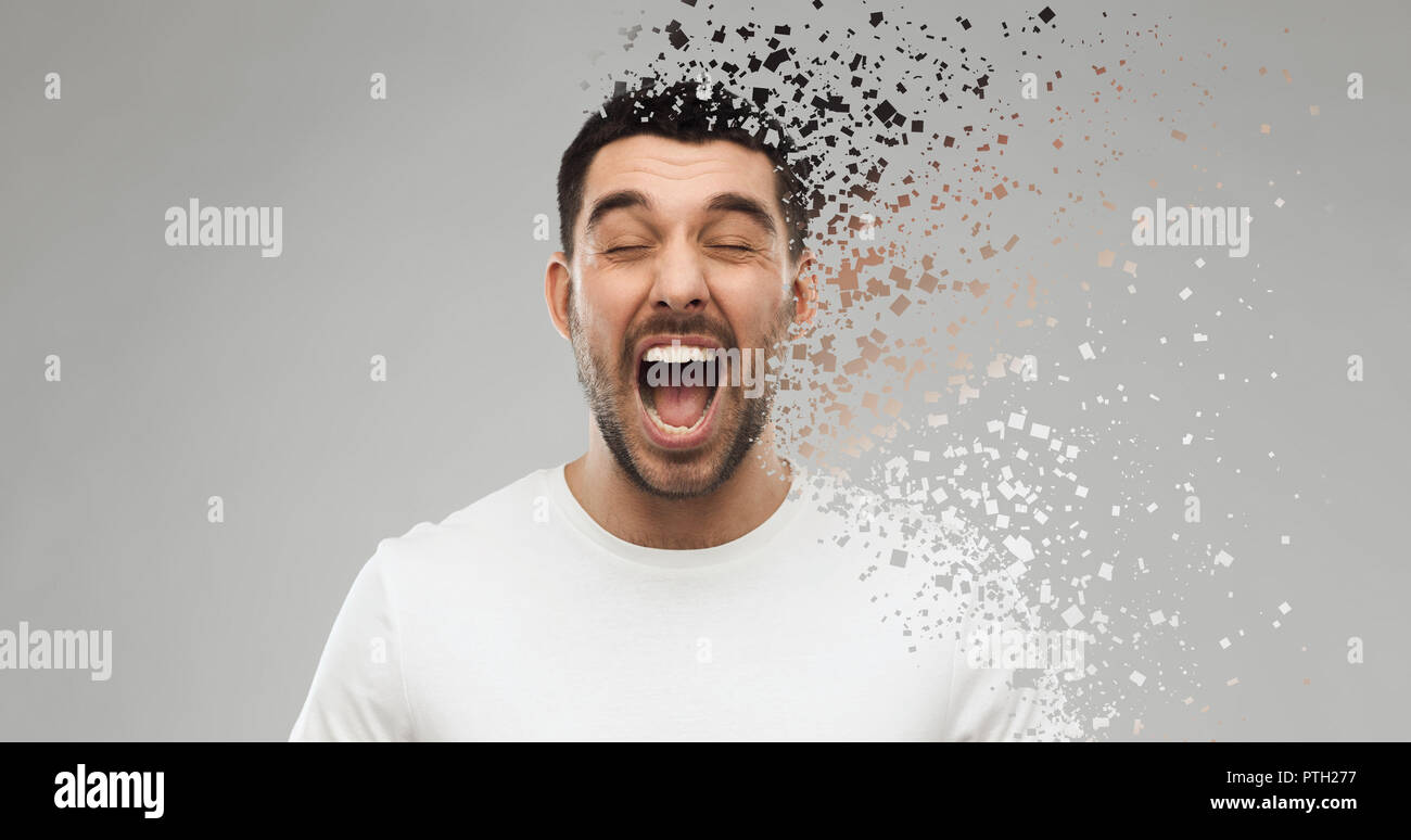 crazy shouting man in t-shirt over gray background Stock Photo