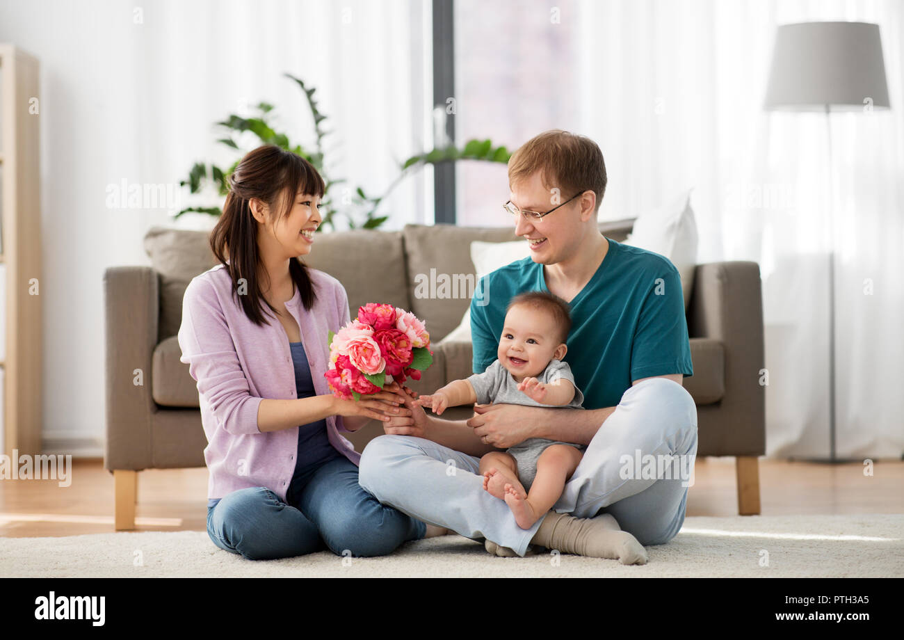 happy family with flowers and baby boy at home Stock Photo Alamy