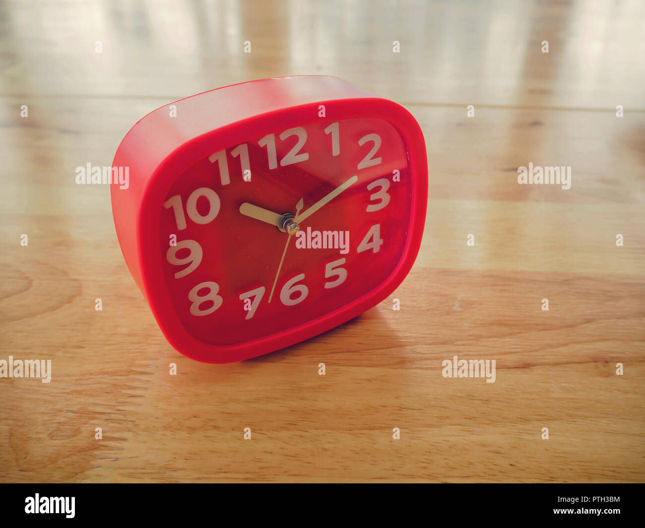 Red rectangle alarm clock on wooden table Stock Photo