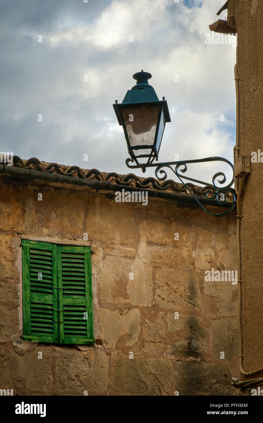Ornamental lantaarn and old shutter in a Mallorcan market town. Stock Photo
