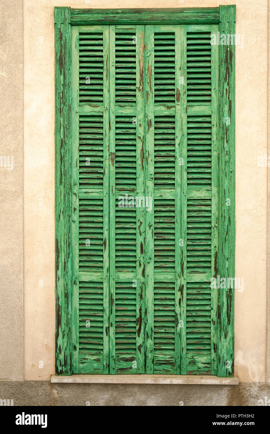 A traditional weather beaten green shutter in Alcúdia, Mallorca, Spain. Stock Photo