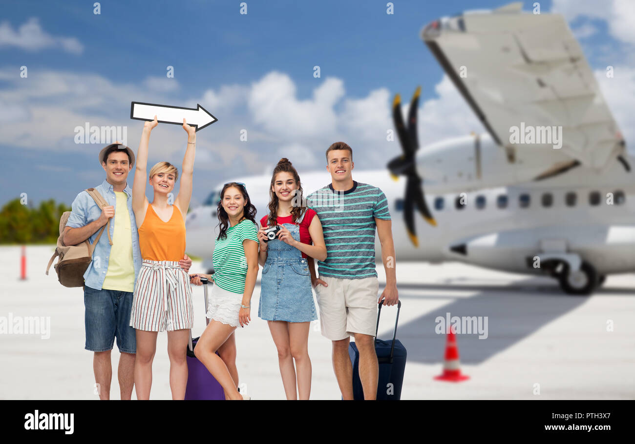 friends with travel bags and arrow over airplane Stock Photo