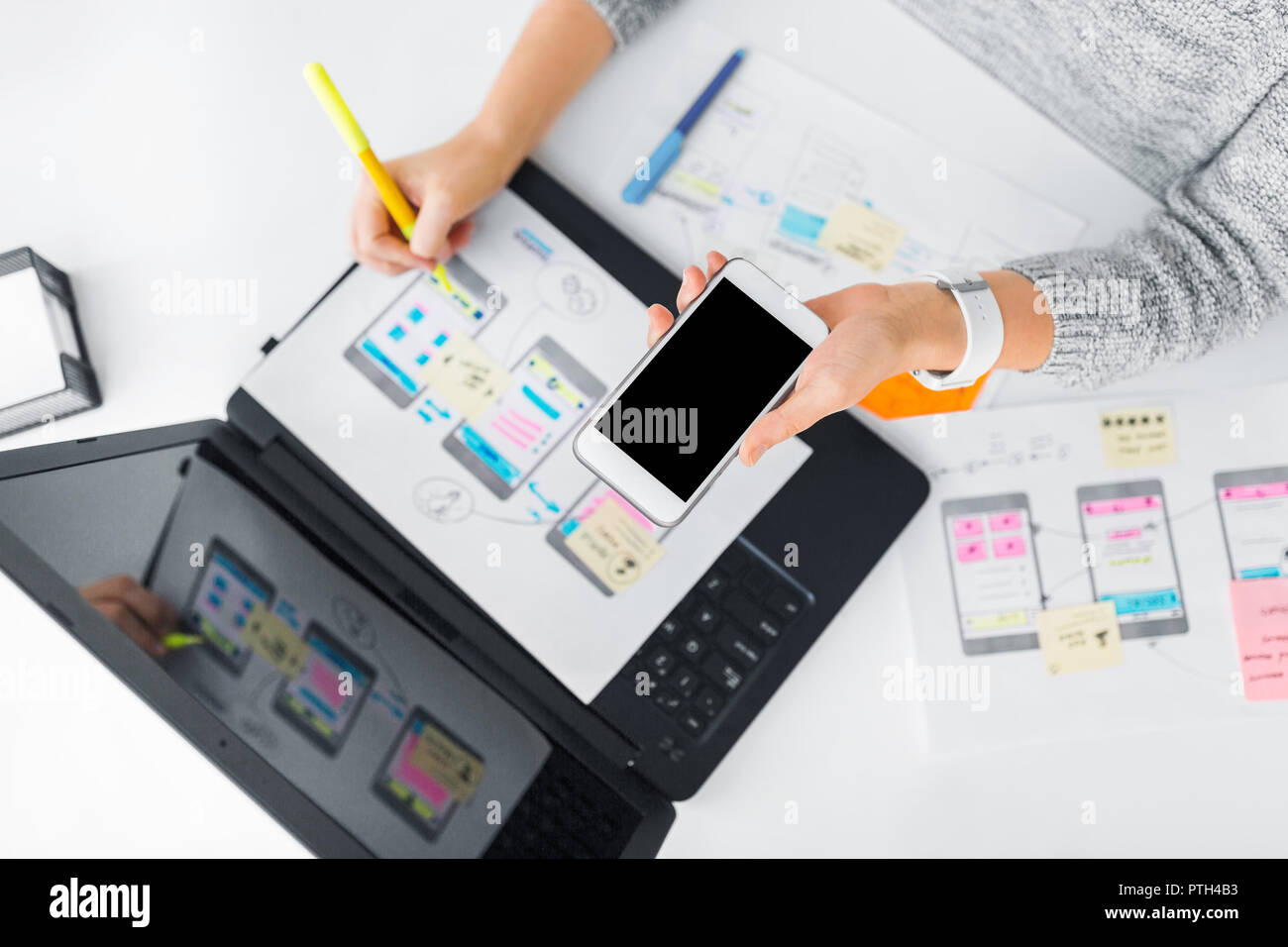 designer with smartphone working on user interface Stock Photo