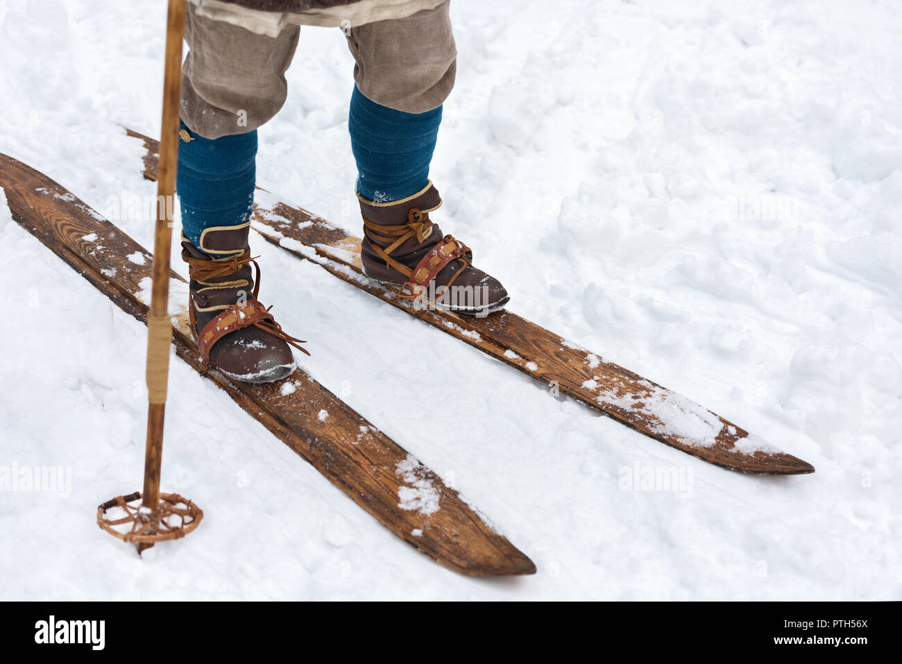 Male feet ancient skier and vintage skis. Historical reconstruction. Leather ski boots and wooden skis Stock Photo