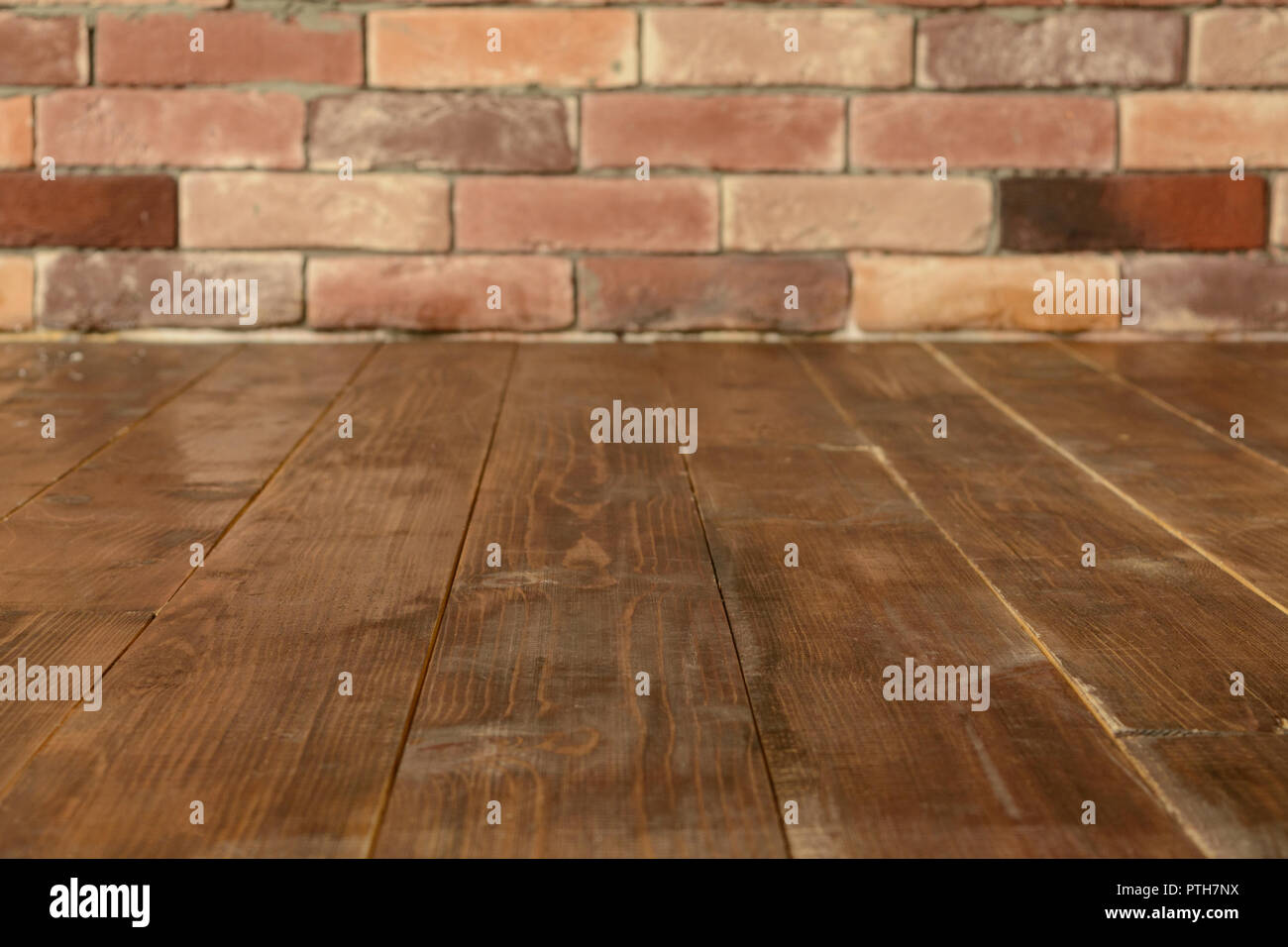 Brown Wooden Floor With Red Brick Wall Background With Copy Space
