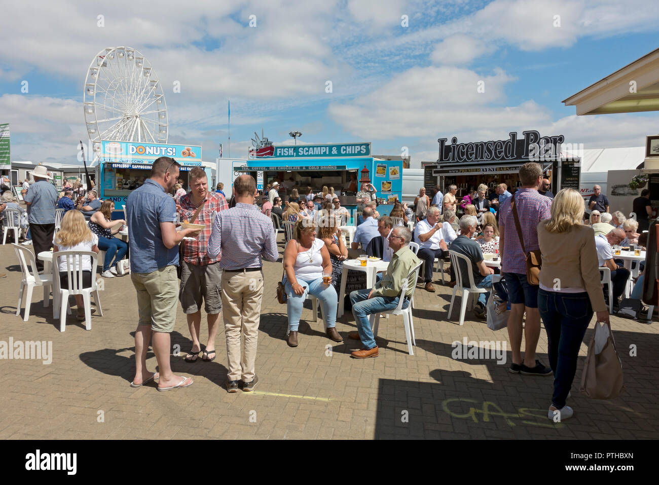 People sitting eating sat outside at food stands at tGreat Yorkshire Show in summer Harrogate North Yorkshire England UK United Kingdom Great Britain Stock Photo