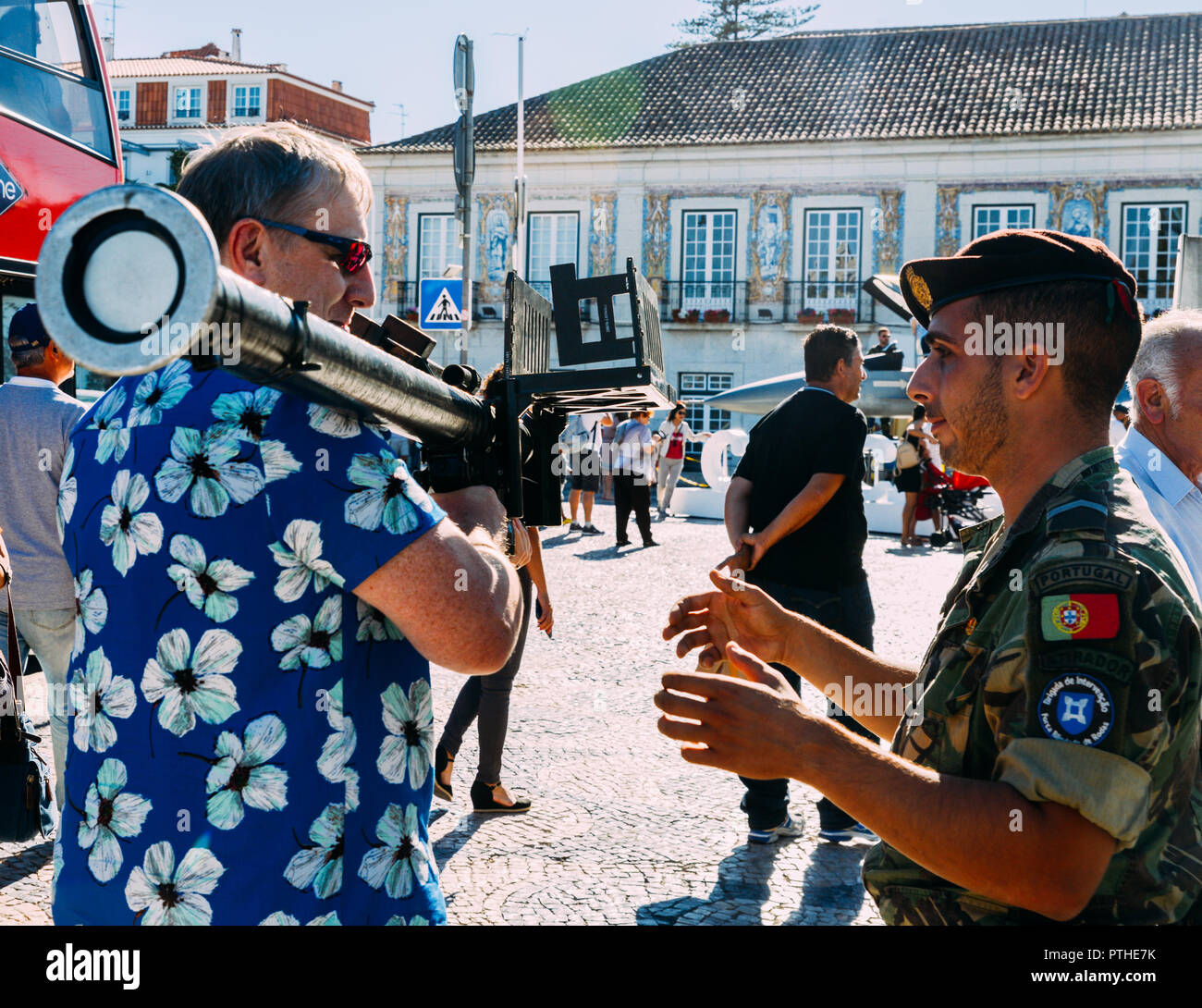 Tourist with hawaiian shirt holding a bazooka at an army expo in Cascais, Portugal. Stock Photo