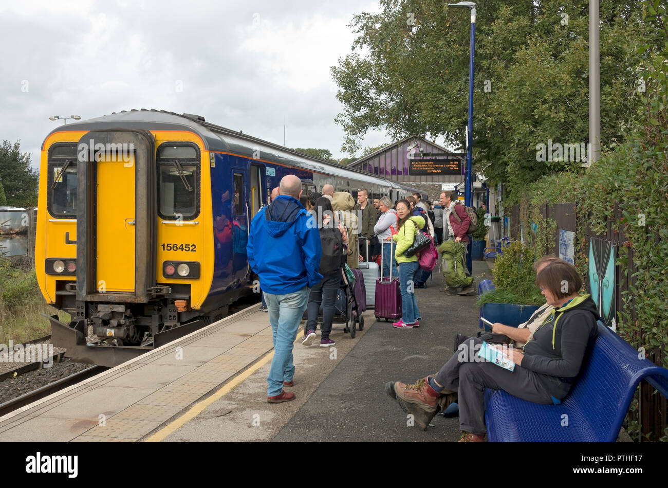 Passengers people getting on a boarding Northern train platform Windermere Railway Station Cumbria England UK United Kingdom GB Great Britain Stock Photo