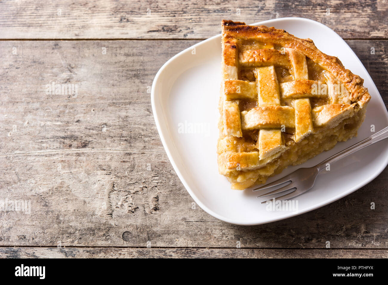 Homemade apple pie slice on wooden table. Copyspace Stock Photo