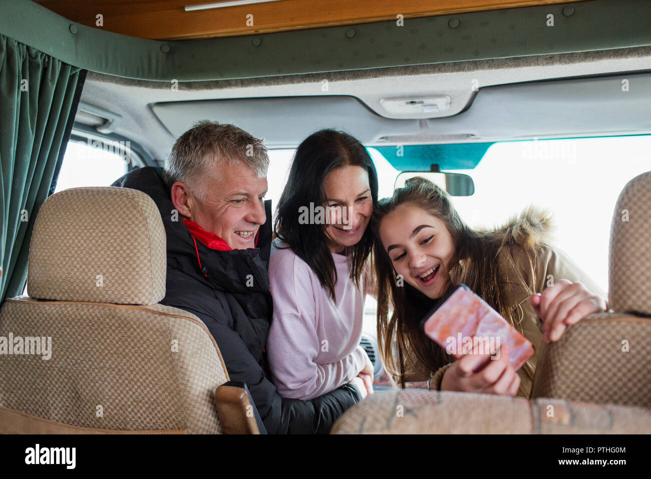 Happy family with smart phone taking selfie in motor home Stock Photo