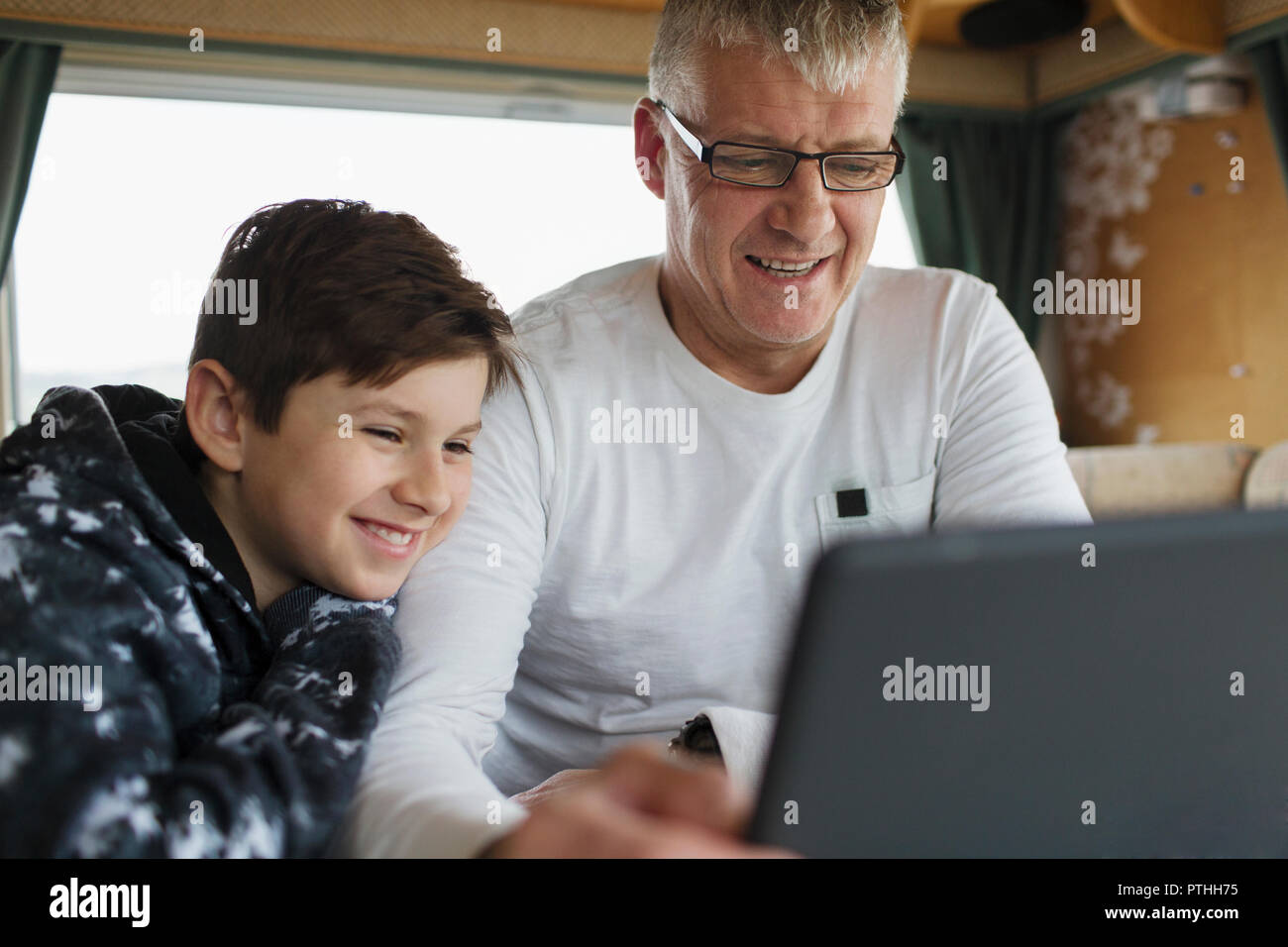 Father and son using digital tablet in motor home Stock Photo