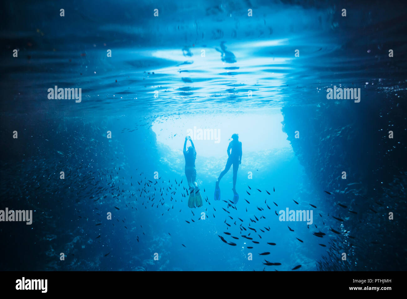 Couple snorkeling underwater among fish, Vava'u, Tonga, Pacific Ocean Stock Photo