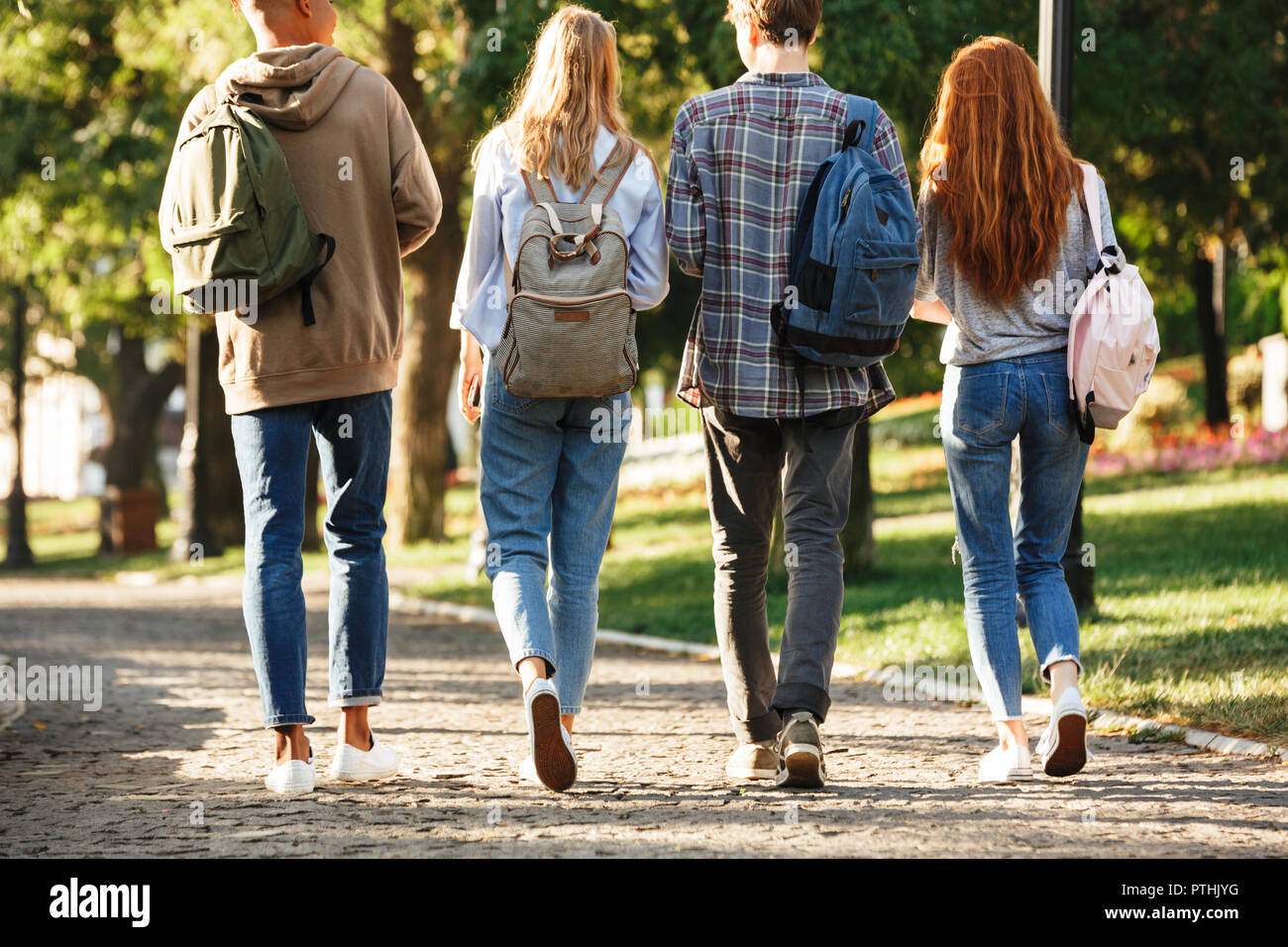 Back view group of students with backpacks walking at the campus ...