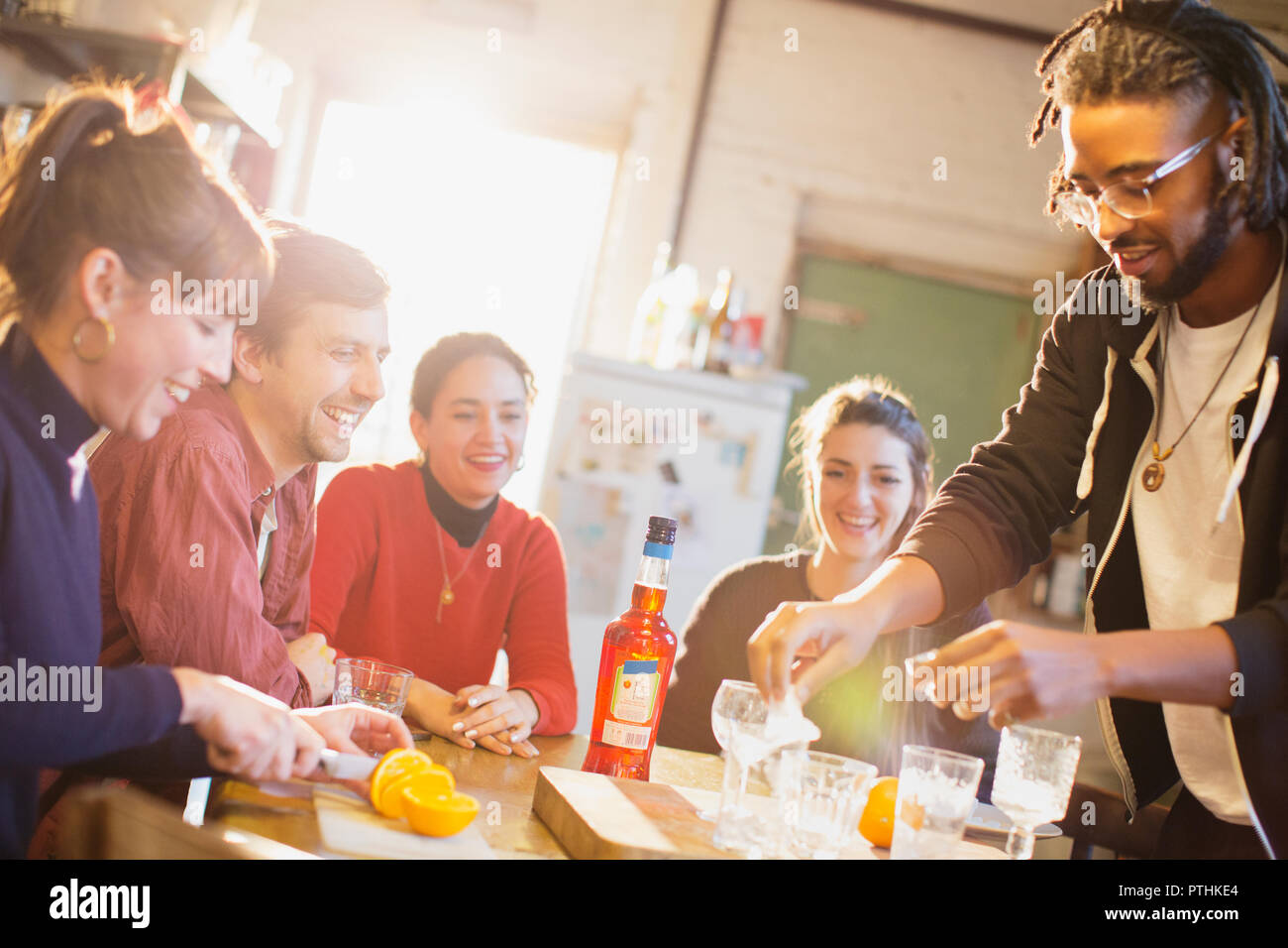Young adult friends making cocktails at kitchen table Stock Photo