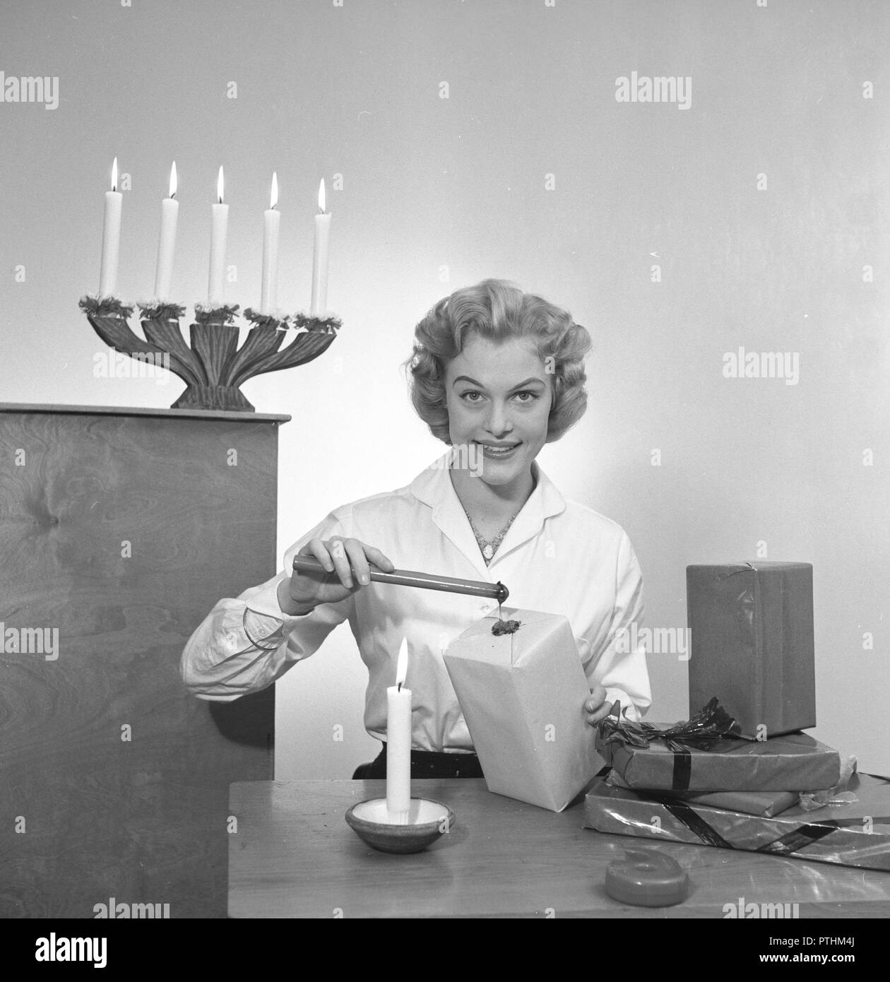 Christmas in the 1950s. Miss Margareta Ehrenfalk is the model for the christmas photo shoot. She is pictured when preparing her christmas presents. Sweden December 1954 Stock Photo