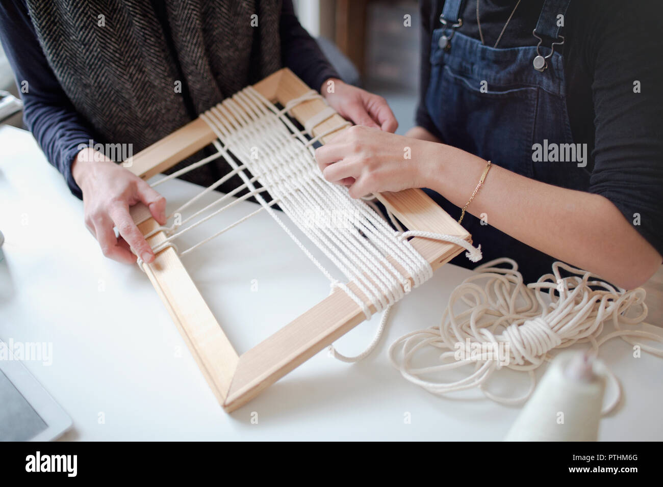 Women friends assembling string frame art Stock Photo