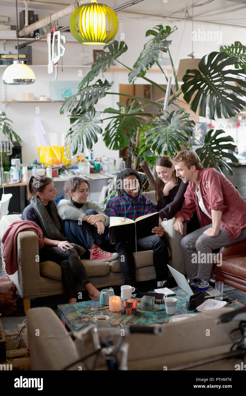 Young adult roommate friends reading book in apartment living room Stock Photo