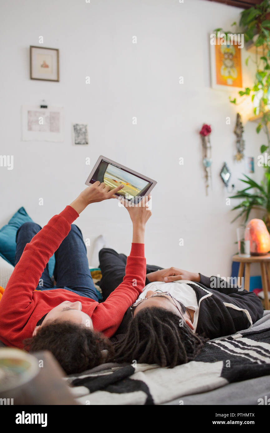 Young couple relaxing, using digital tablet on bed Stock Photo
