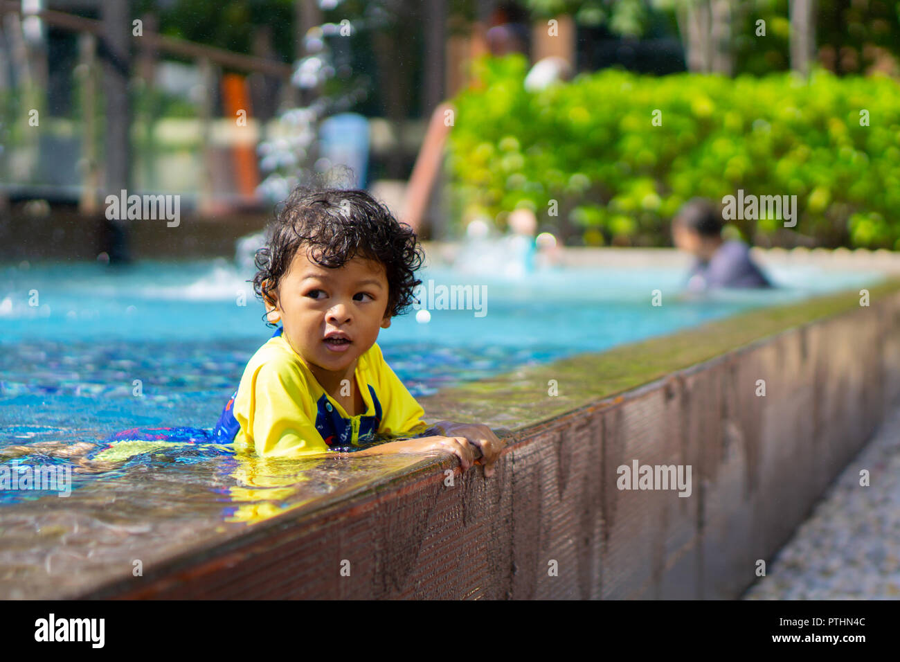Asian child boy learn swimming in a swimming pool. Stock Photo