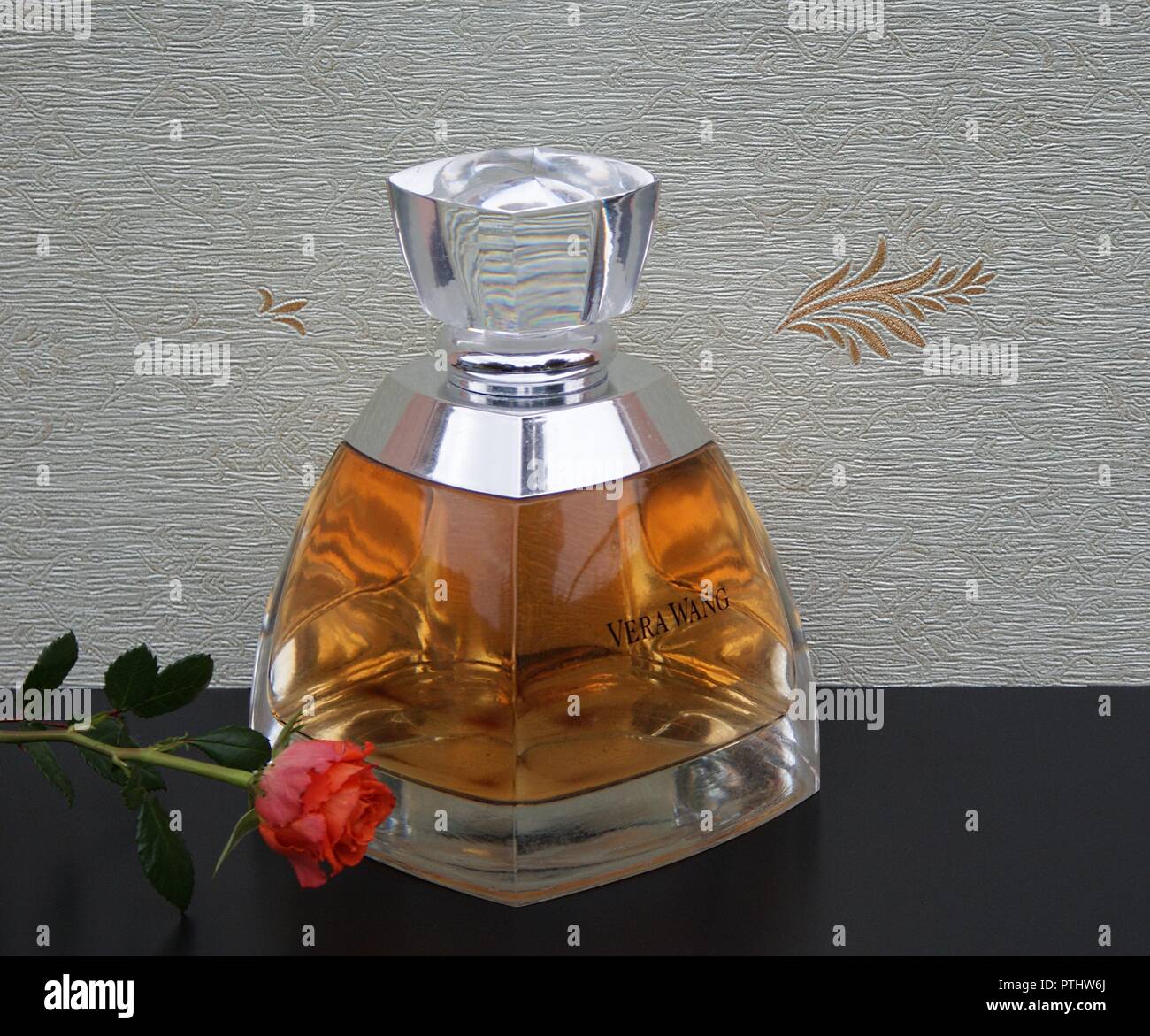 Vera Wang, fragrance for ladies, large perfume bottle in front of the satin wallcovering Elysee decorated with an English rose Stock Photo