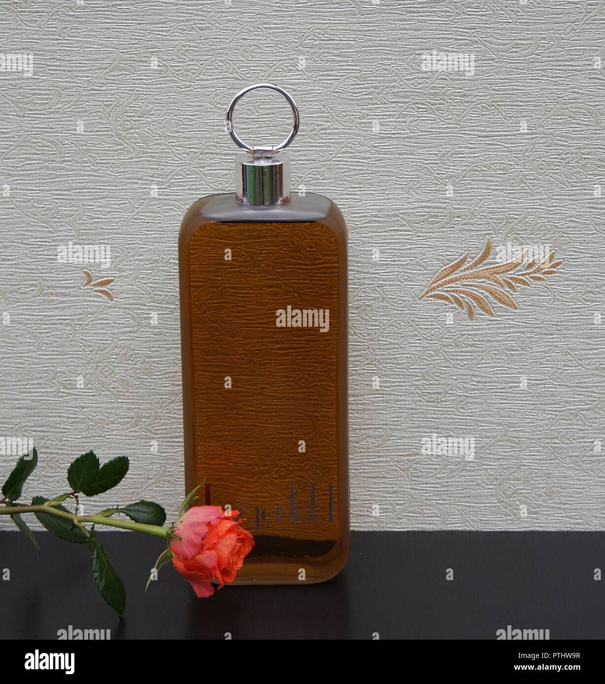Lagerfeld, men's fragrance, large perfume bottle in front of the satin wallcovering Elysee decorated with an English rose Stock Photo