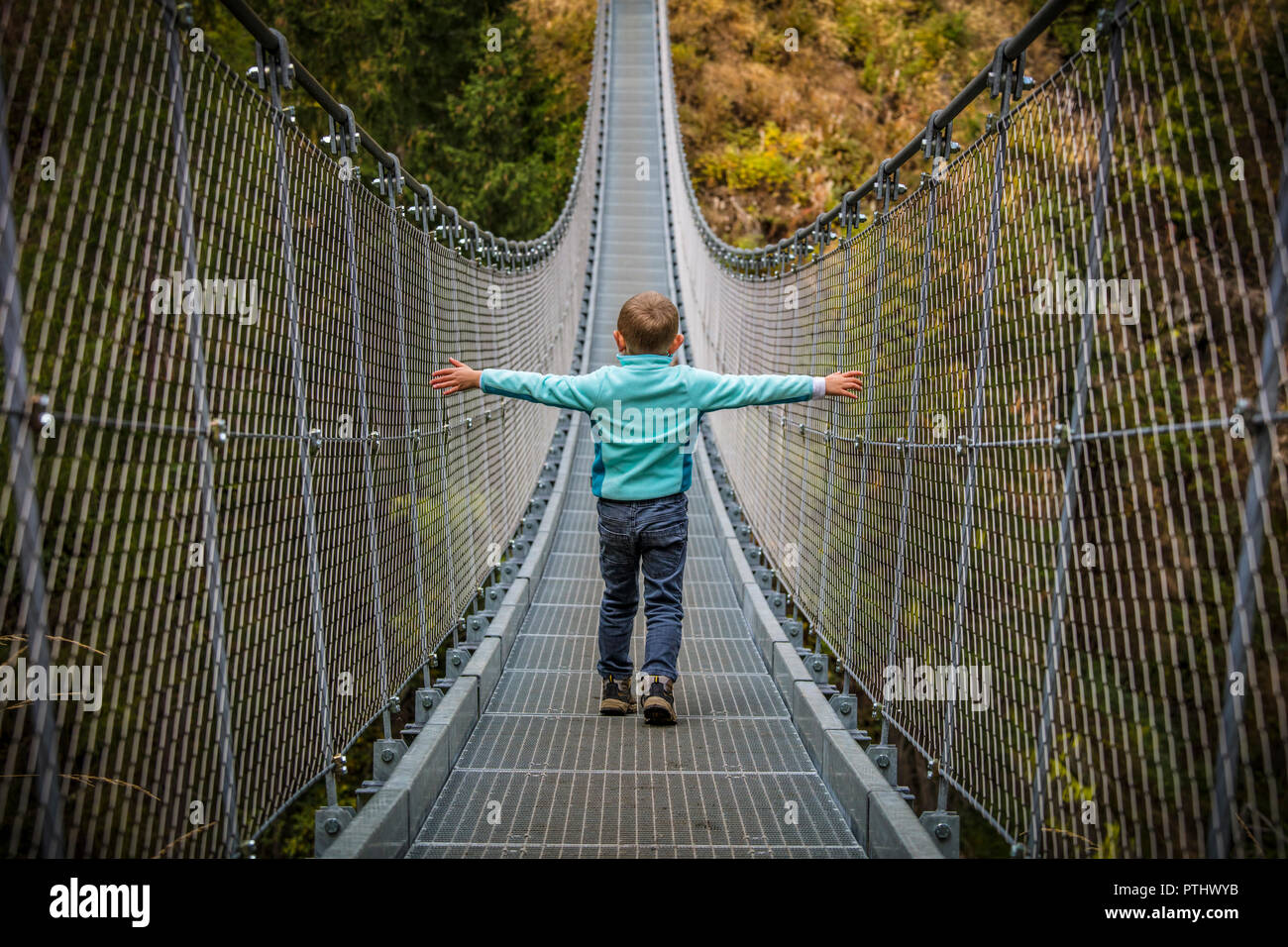 kid walk on suspended bridge in rabby valley Stock Photo