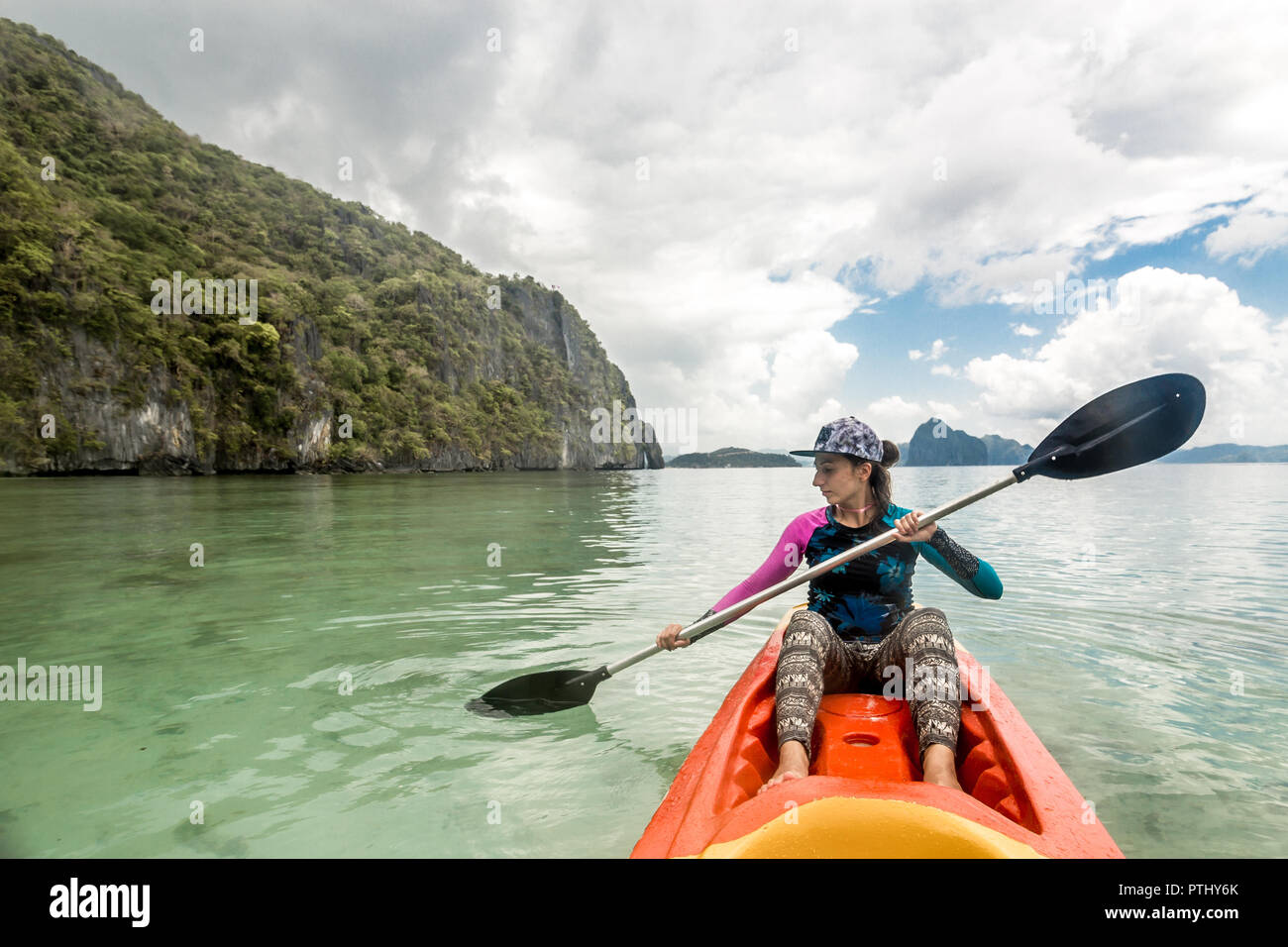Woman Paddling A Kayak In The Island Mountains Kayaking In El Nido