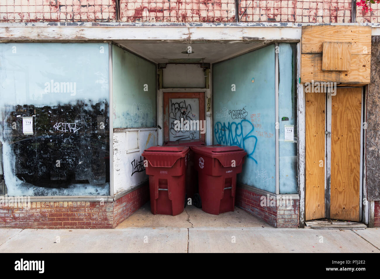 JOHNSON CITY, TN, USA-9/30/18: An abandoned and deteriorating downtown commercial building with new trashcans setting in entrance. Stock Photo