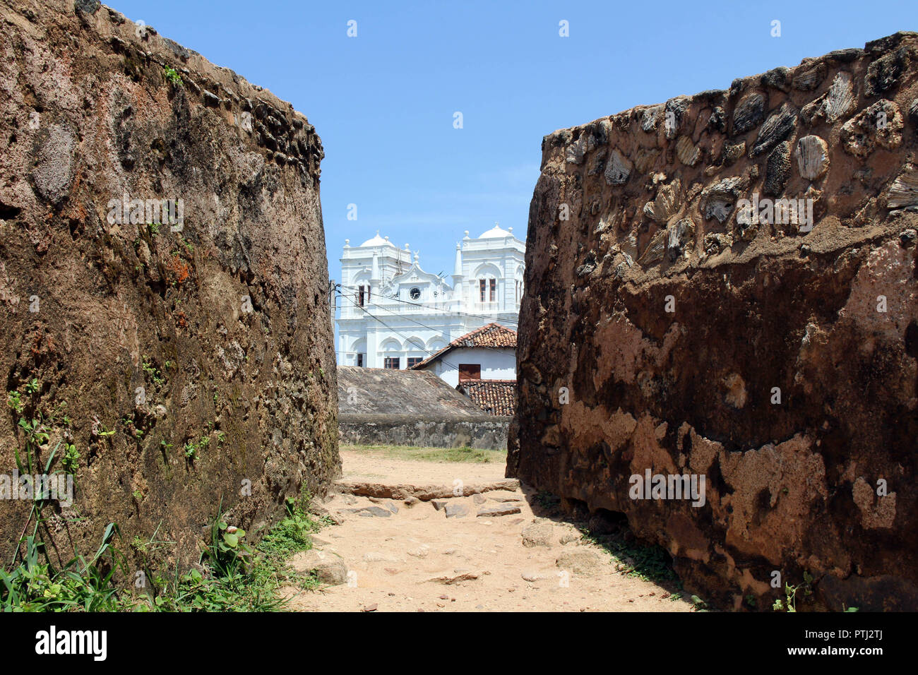 The Meera Mosqe within the Galle Fort, seen from between of two rocks. Taken in Sri Lanka, August 2018. Stock Photo