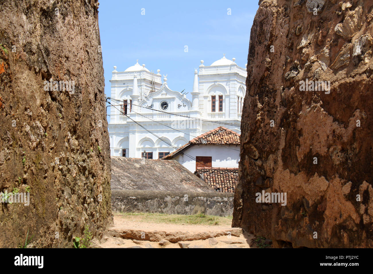 The Meera Mosqe within the Galle Fort, seen from between of two rocks. Taken in Sri Lanka, August 2018. Stock Photo