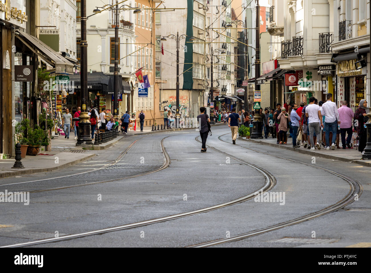 Hüdavendigar street with tram lines running along it as people walk on the pavement alongside, Istanbul, Turkey Stock Photo
