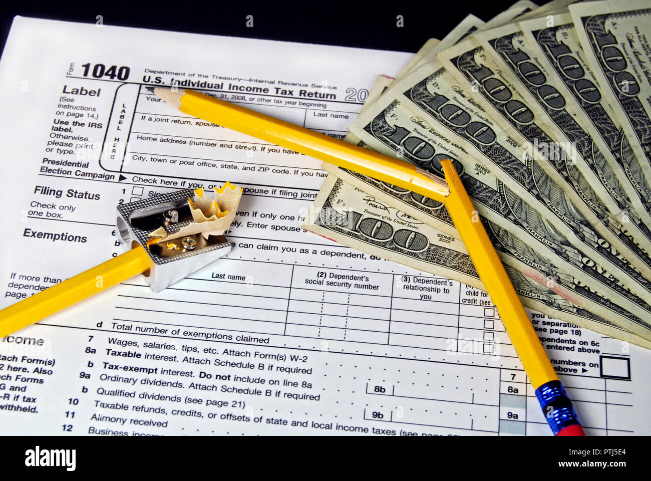 Money and broken pencil on an income tax form. Stock Photo