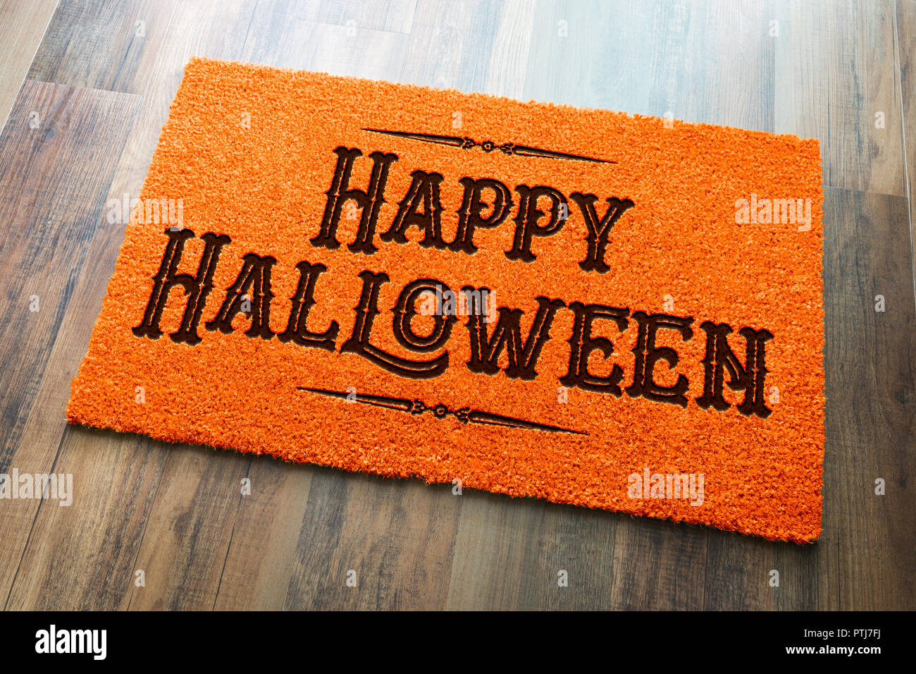 Happy Halloween Orange Welcome Mat On Wood Floor Background. Stock Photo