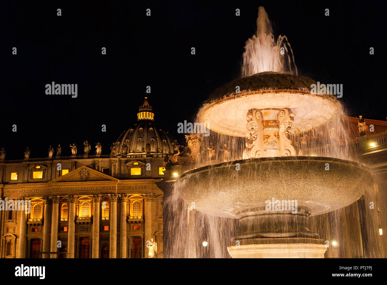 Wonderful Saint Peter Basilica and old fountain lit up at night Stock Photo