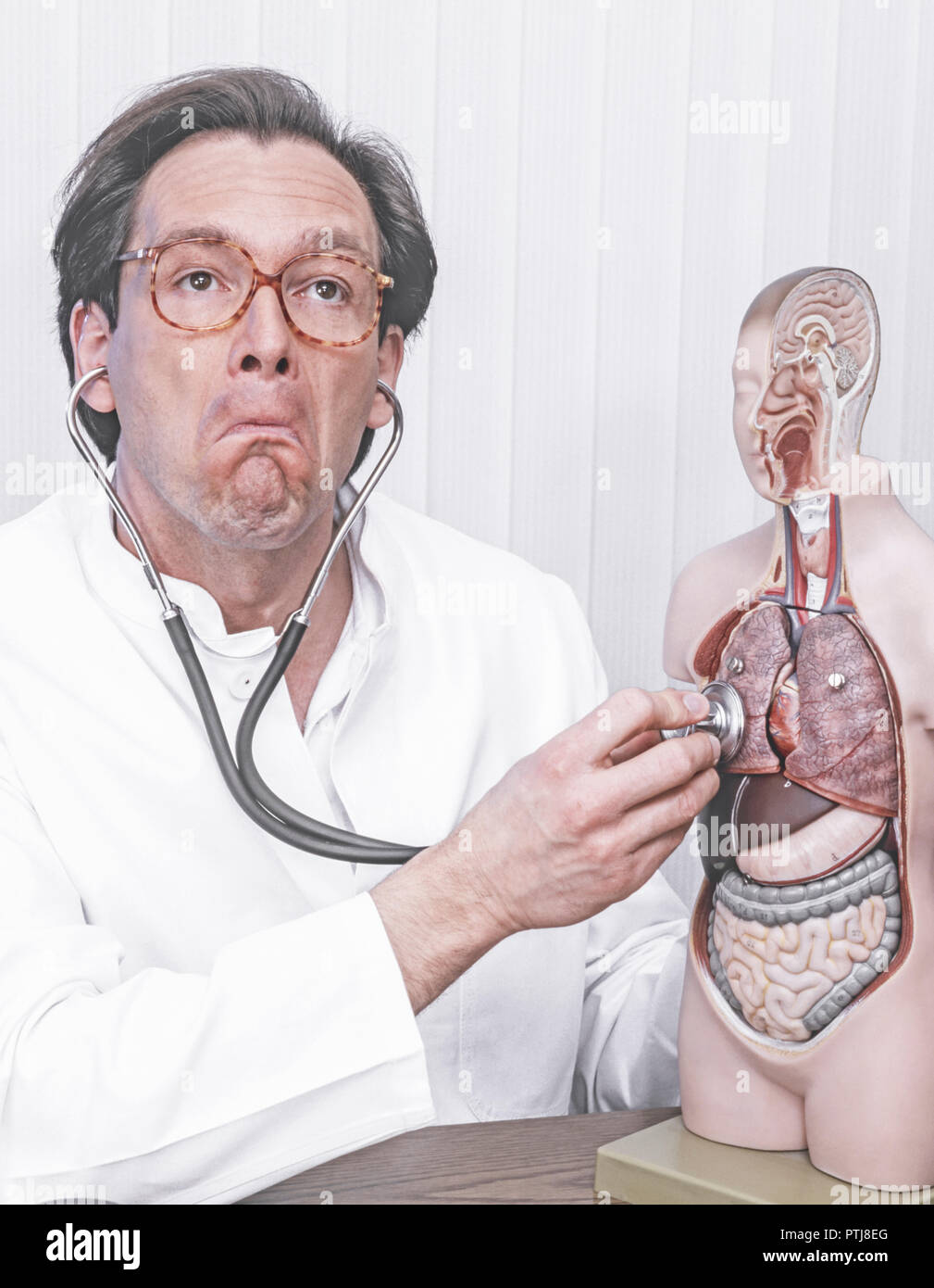 Arzt hoert mit dem Stethoskop an einem Modell Mimik (Modellfreigabe) Stock Photo