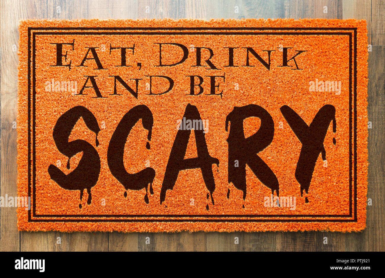 Eat, Drink and Be Scary Halloween Orange Welcome Mat On Wood Floor Background. Stock Photo