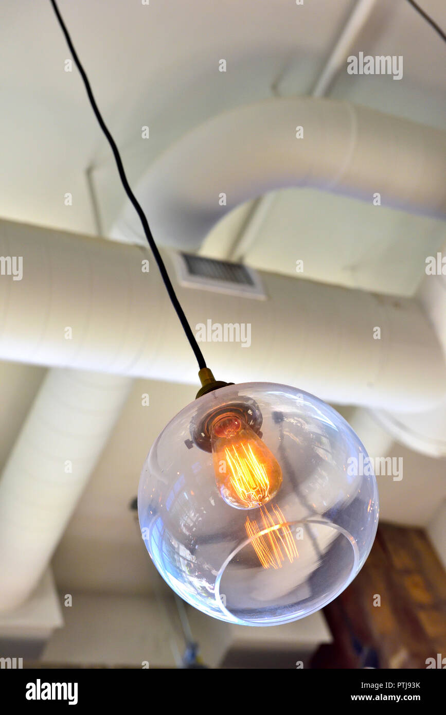 Modern LED lamp in hanging globe light fitting, commercial environmen Stock Photo