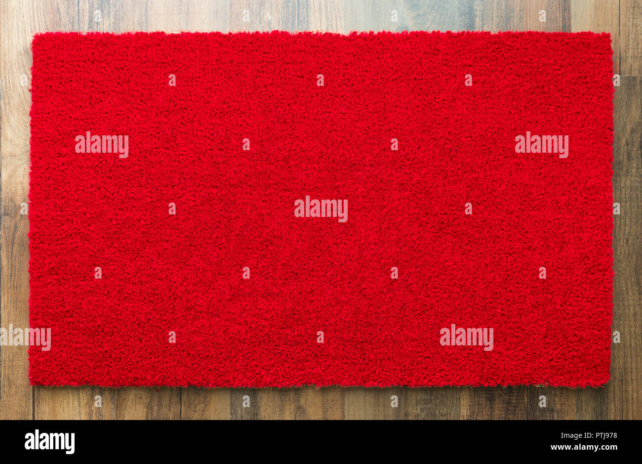 Blank Red Welcome Mat On Wood Floor Background Ready For Your Own Text. Stock Photo