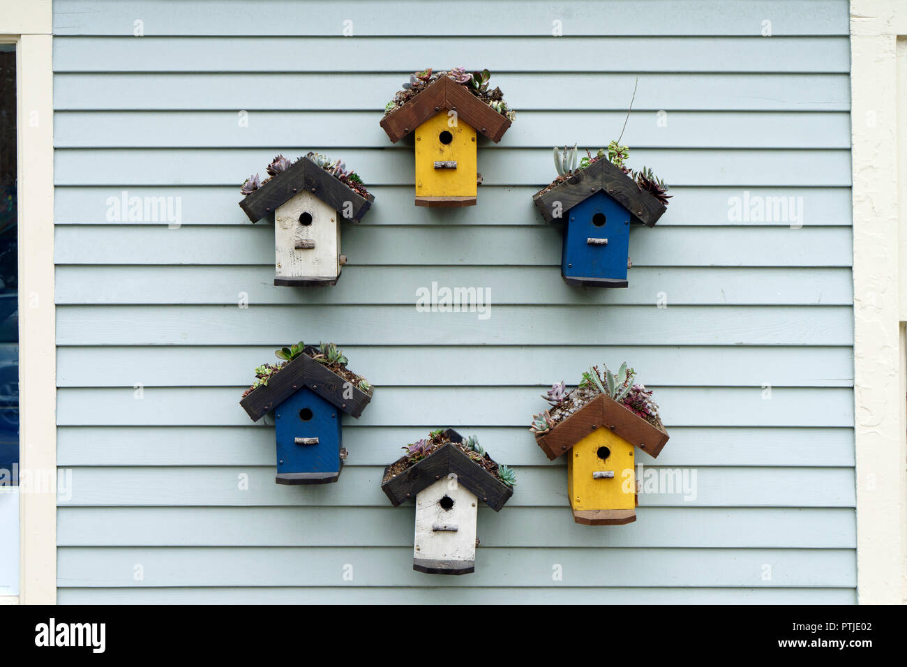 Wooden birdhouses on display on the exterior wall of a boutique in the state of Maine, USA. Stock Photo