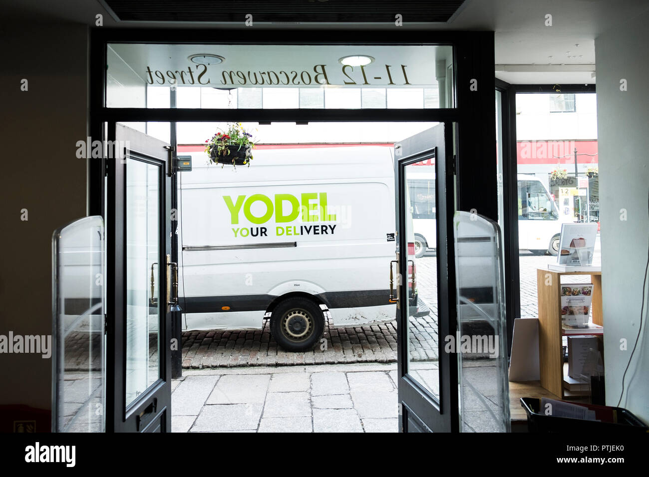 A Yodel delivery van vehicle parked outside a shop store in Truro City