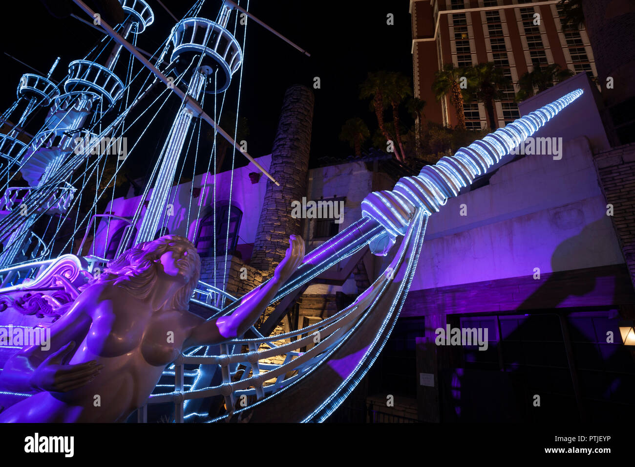 Illuminated pirate ship with statue representing a siren at Treasure Island Hotel and Casino, Las Vegas, Nevada, USA. Stock Photo