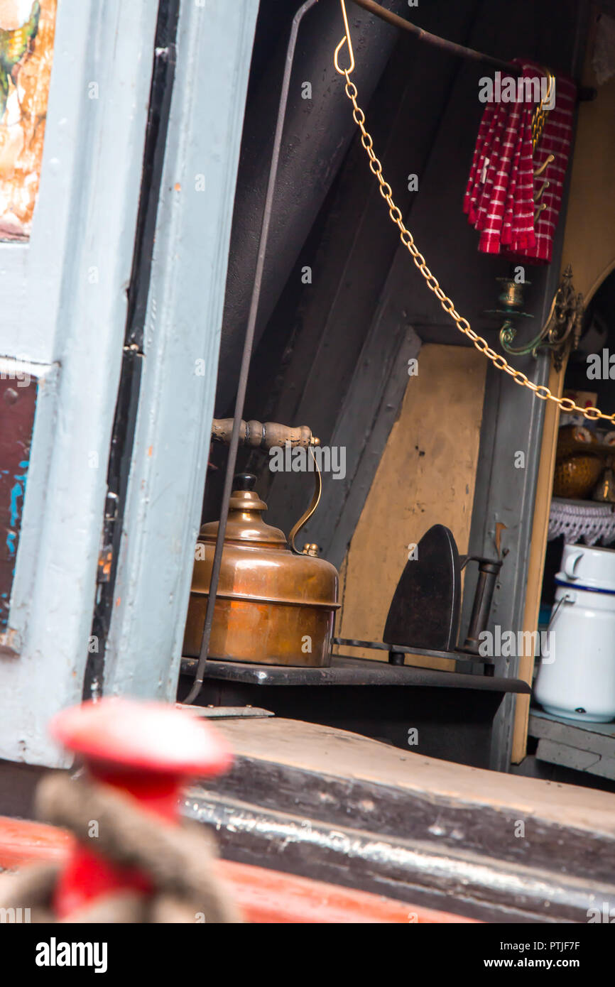 Looking inside old-fashioned galley area of vintage narrowboat UK. Canal boat interior. Stock Photo