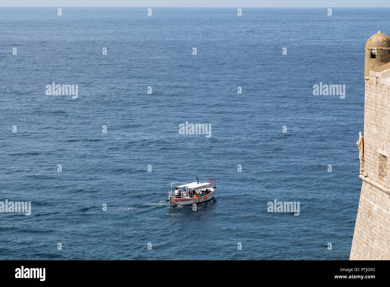 Boat passing the old walls of Dubrovnik. Stock Photo