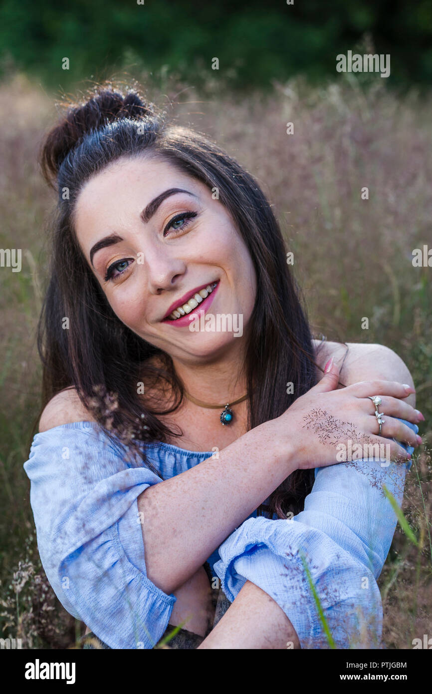 Portrait of a young woman in a grass meadow near Liverpool. Stock Photo
