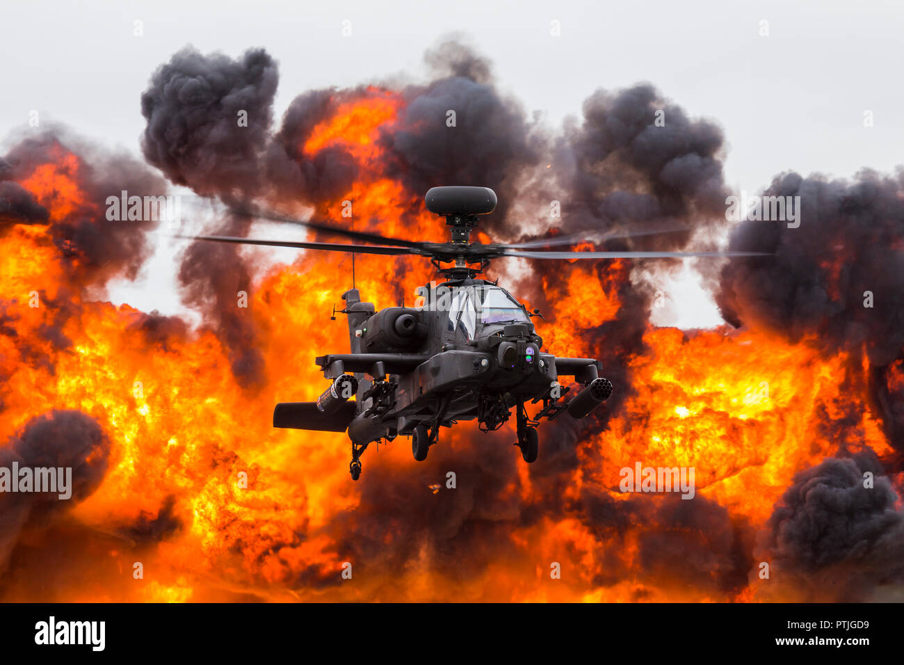 Army Air Corps WAH-64D Apache in front of a wall of fire. Stock Photo
