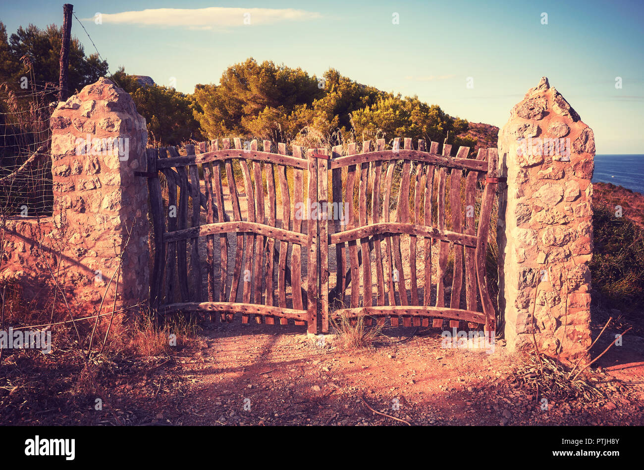 Old wooden closed fence at sunset, vintage toning applied. Stock Photo